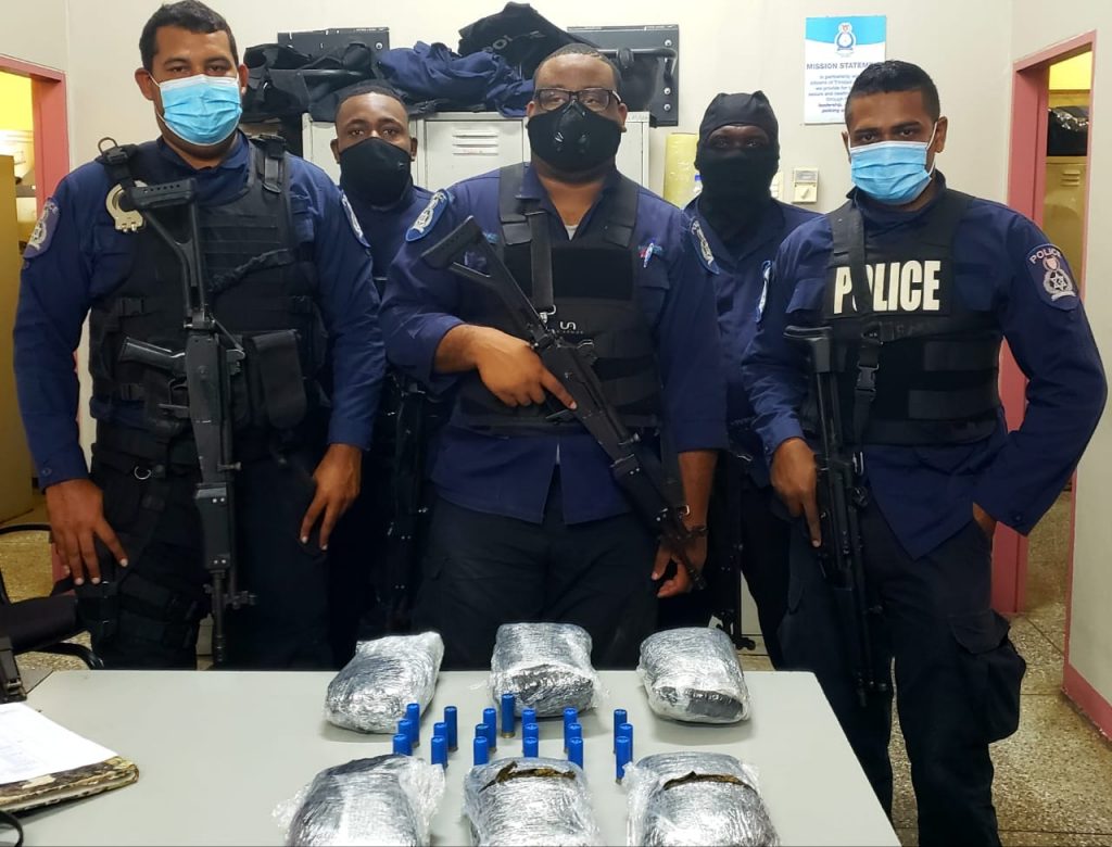 Officers of the Port of Spain Task Force pose near three kilograms of marijuana and 19 shotgun shells seized at an abandoned house in Belmont on Wednesday afternoon. 

PHOTO COURTESY TTPS