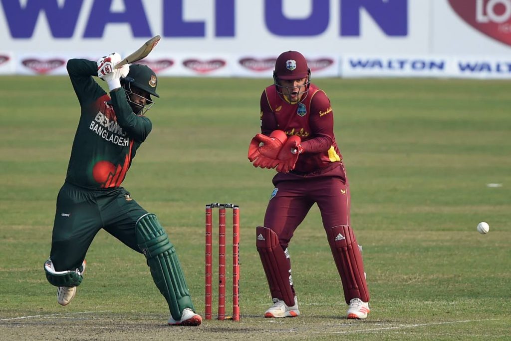 Bangladesh's captain Tamim Iqbal (left) plays a shot as West Indies' wicketkeeper Joshua Da Silva watches during the second ODI between Bangladesh and West Indies at the Sher-e-Bangla National Cricket Stadium in Dhaka on Friday. (AFP PHOTO) - 