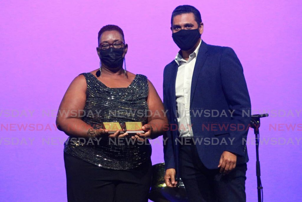A WINNER: Michelle Dowrich, left, collected the first place plaque the St Joseph Convent, San Fernando choir from Larry Olton, head of the Brand and Marketing Department of First Citizens at the Music Festival prize giving ceremony, at Naparima Bowl, San Fernando on Friday. - CHEQUANA WHEELER