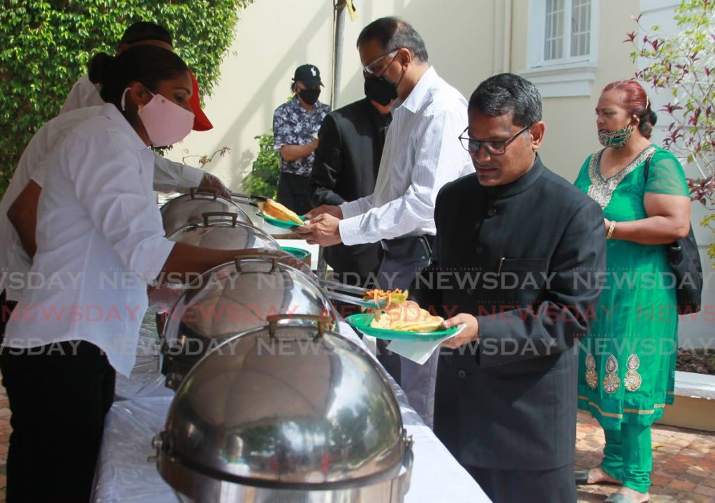 Indian High Commissioner to TT Arun Kumar Sahu samples some of the food from a traditional Indian breakfast during the ceremony commemorating the 72nd Republic Day of India at his Maraval residence. - ROGER JACOB