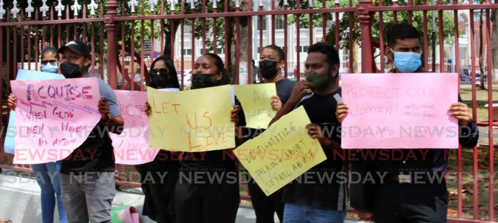 Men and women call for justice for women victims of violence and murder outside Parliament on Friday. PHOTO BY SUREASH CHOLAI - 