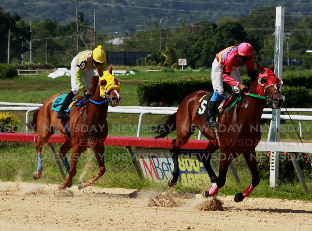 Jockey Andrew Poon (right) rides Integrity to victory ahead of Sentebale’s Dillon Khelewan in Race II, at the Arima Race Club’s Saturday races, at the Santa Rosa Track, Arima. - ROGER JACOB