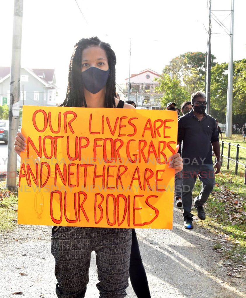 TT, HEED THIS: A woman displays a placard with a message to the nation as she and hundreds more marched against crime on Sunday around the Queen’s Park Savannah. PHOTO BY VIDYA THURAB - 