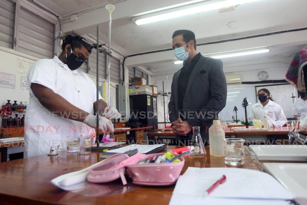 Vickram Ramlal, 18, demonstrates an experiment to Attorney General and San Fernando West MP, Faris Al-Rawi as students of the San Fernando Central Secondary School, form five science class, return to school after being away due to the covid 19 pandemic. - Lincoln Holder