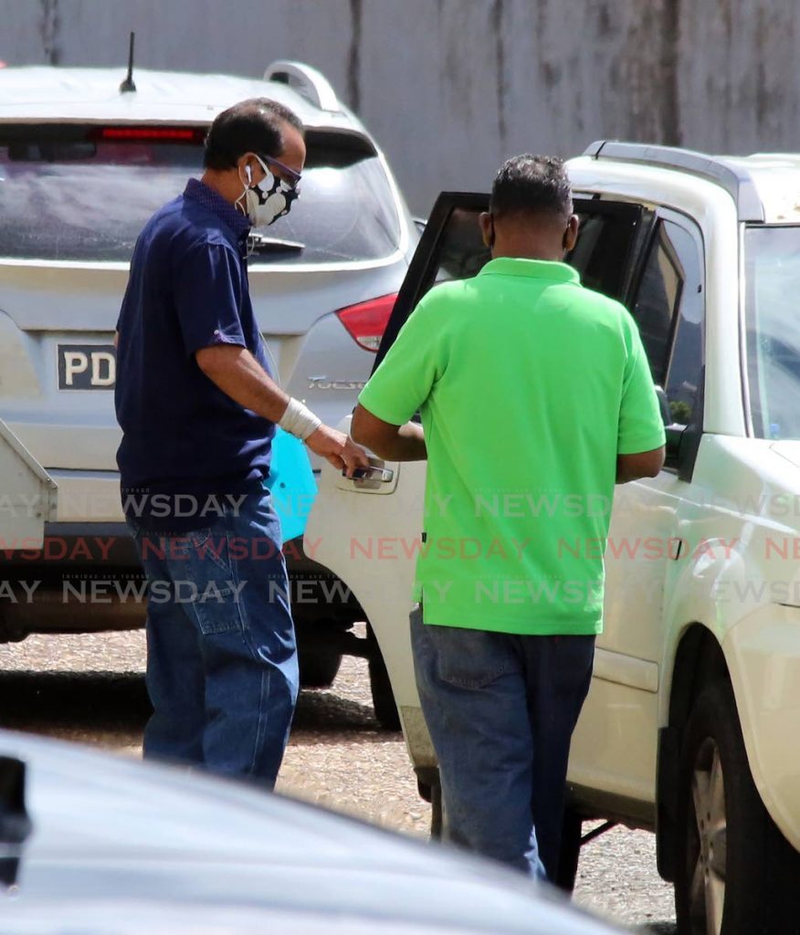 Andrea Bharatt's father Randolph Bharatt (left)  leaving  the back entrance of Forensic Science Centre  on Barbados Road, Port of Spain on Monday. - SUREASH CHOLAI