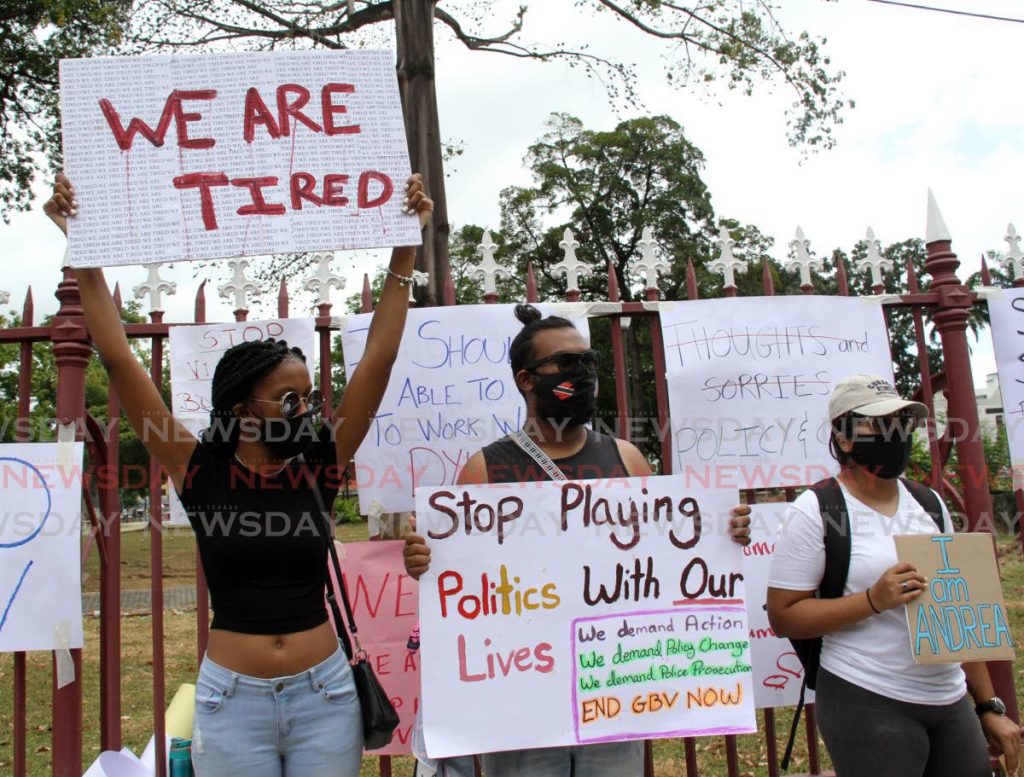 Protesters display placards opposite the Red House, in the hope that lawmakers would hear their plea to to make protection for women a priority. Photos by Angelo Marcelle
