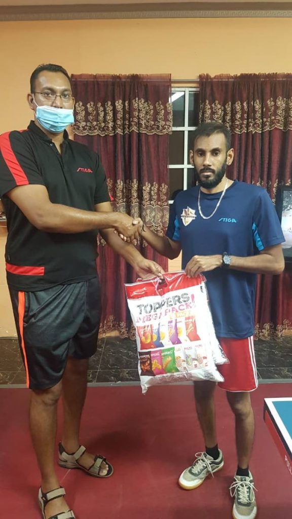 Hillview Renegades' Kirk Mohammed, left, presents Tuesday's Table Tennis Champions League MVP Yuvraaj Dookram with a special prize from sponsors Toppers Snacks.  - 