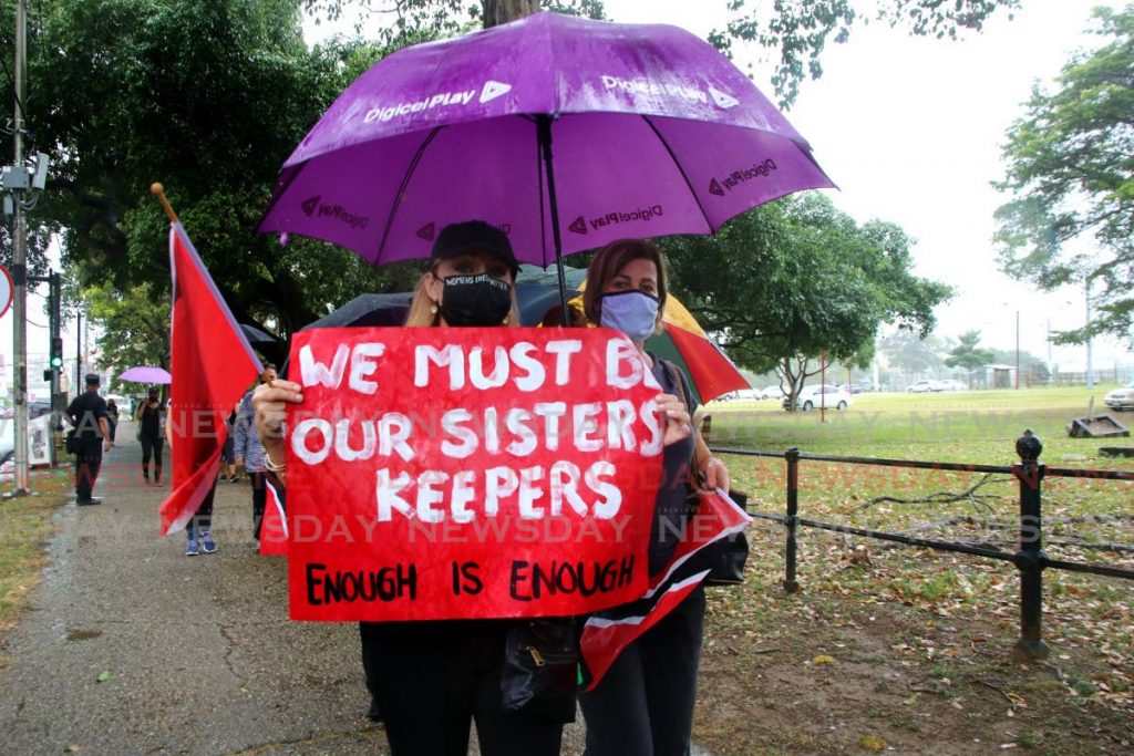 ENOUGH IS ENOUGH: These women were among hundreds of people who braved the rainy weather on February 13 in a protest march at the Queen’s Park Savannah over violence against women. File photo by Sureash Cholai 