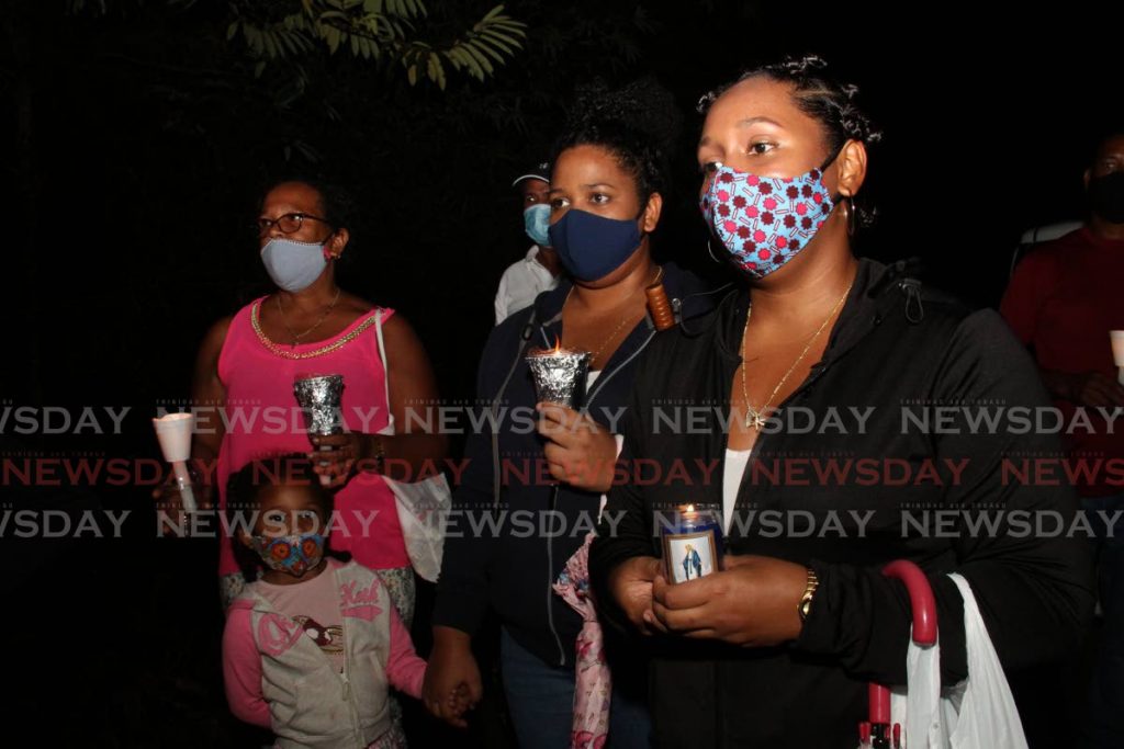 Women and girls attend the candlelight vigil at the Heights of Aripo on Friday in memory of murder victim Andrea Bharatt. - 