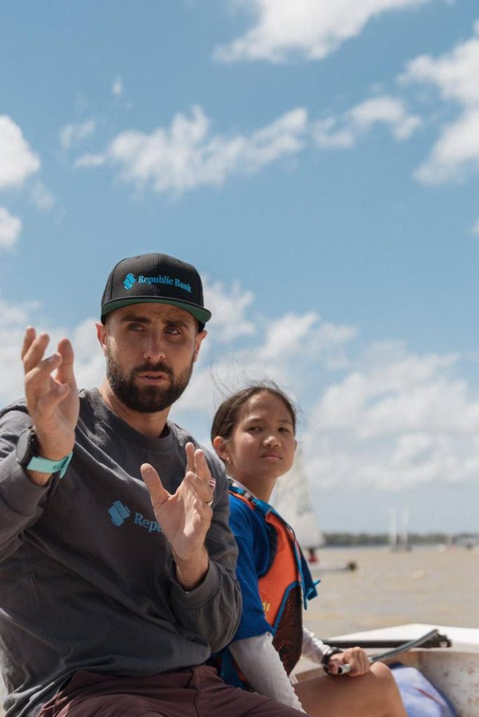 Olympic sailor Andrew Lewis guides a young sailor at the Andrew Lewis Sailing Foundation 'Mentoring through Sailing' programme at Vessigny Beach over the weekend.  - Melvern Isaac