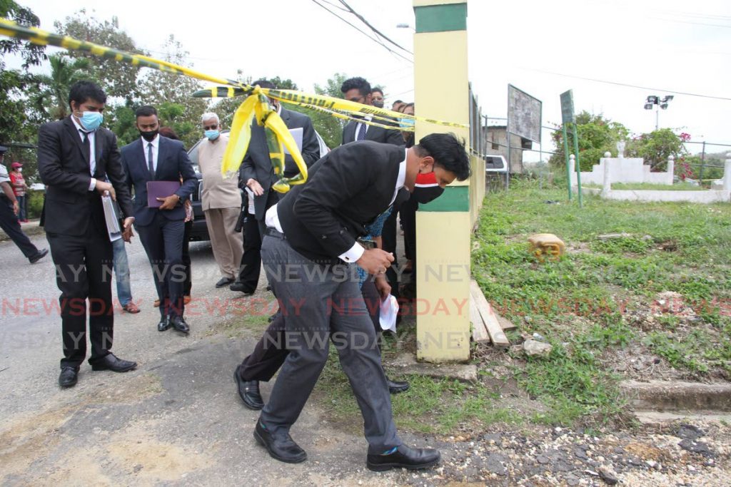 Justice Frank Seepersad ducks under a caution tape to enter the Monkey Town public cemetery in Barrackpore on Tuesday last week. - 