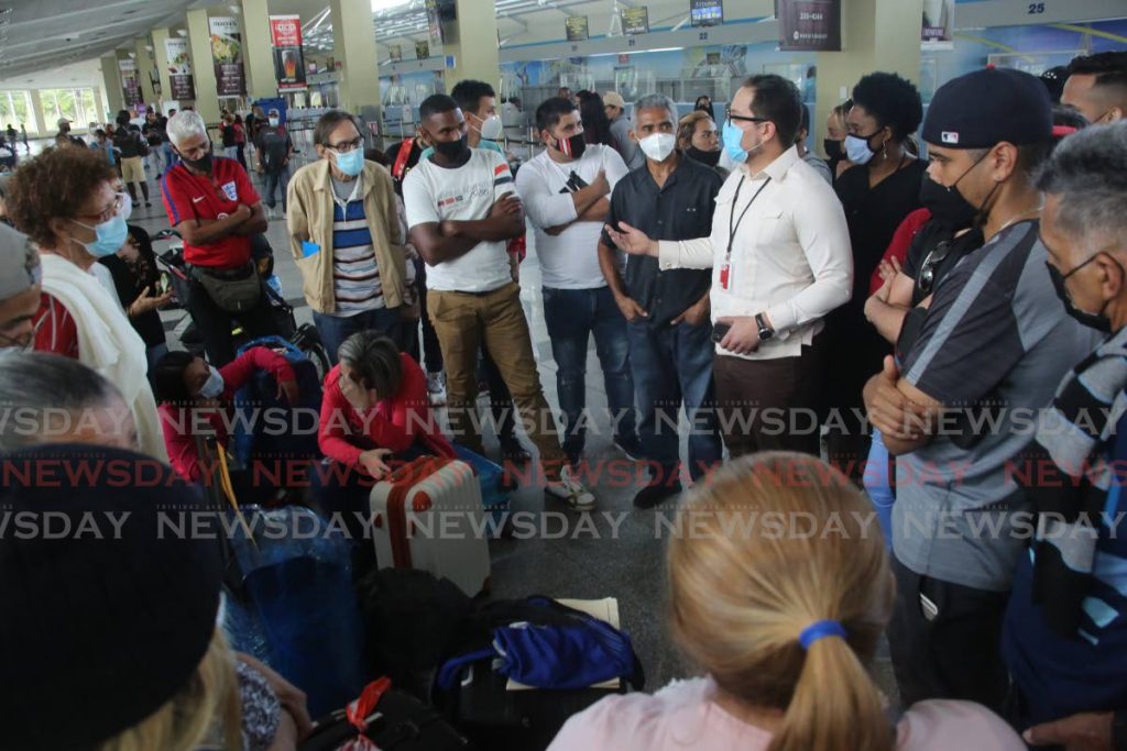 STRANDED: An official speaks with a group of Venezuelans at Piarco Airport on Thursday after a flight from Caracas which was supposed to land to repatriate them home, was later cancelled. PHOTO BY SUREASH CHOLAI - 