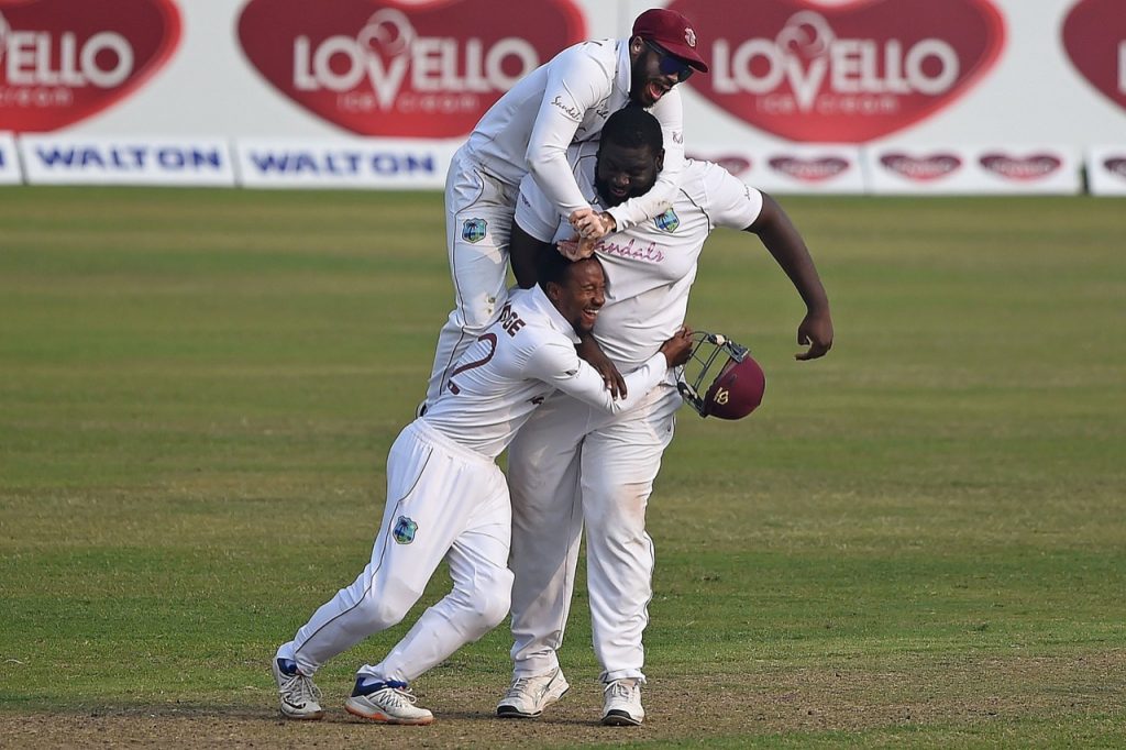 West Indies players mob spinner Rahkeem Cornwall after taking a wicket against Bangladesh on day four of the second Test in Dhaka, Bangladesh on Sunday. PHOTO COURTESY CWI