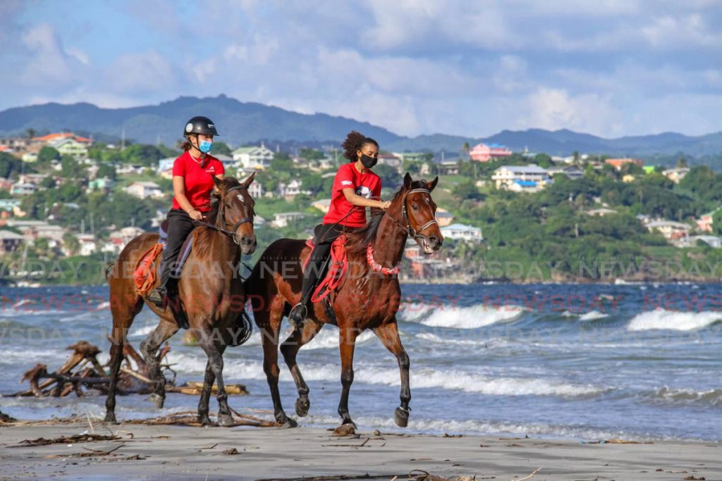 Emma Knott, left, rides her horse Aphrodite alongside Jade Feniet atop Apollo, on the beach at the Magdalena Grand Beach and Golf Resort in Tobago on October 15, 2020. Tourism officials report a 76 per cent occupancy rate ahead of the Easter holidays. File photo/Ayanna Kinsale  - 