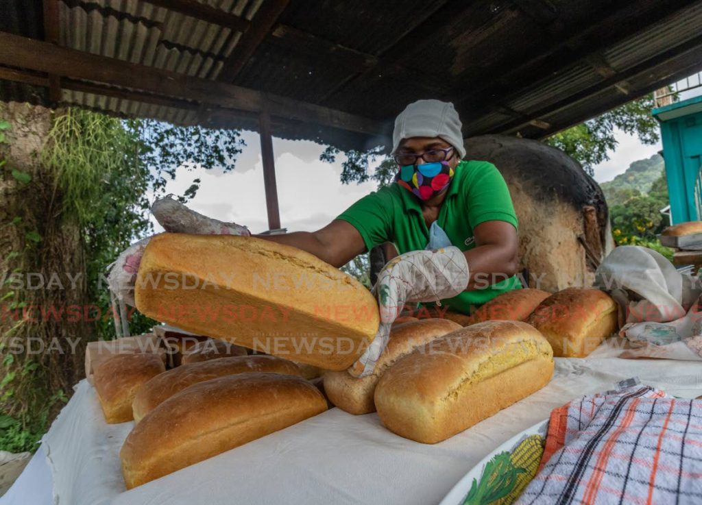 Judy Manswell places pumpkin bread from a dirt oven on a table in L-Anse Fourmi.  Photos by Jeff K Mayers