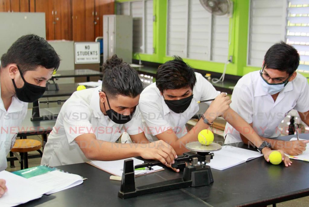 Former five students conduct a physics experiment at Tunapuna Secondary School on February 10. Financial advisers give tips on how parents can plan for their children's higher education. Photo by Roger Jacob - 