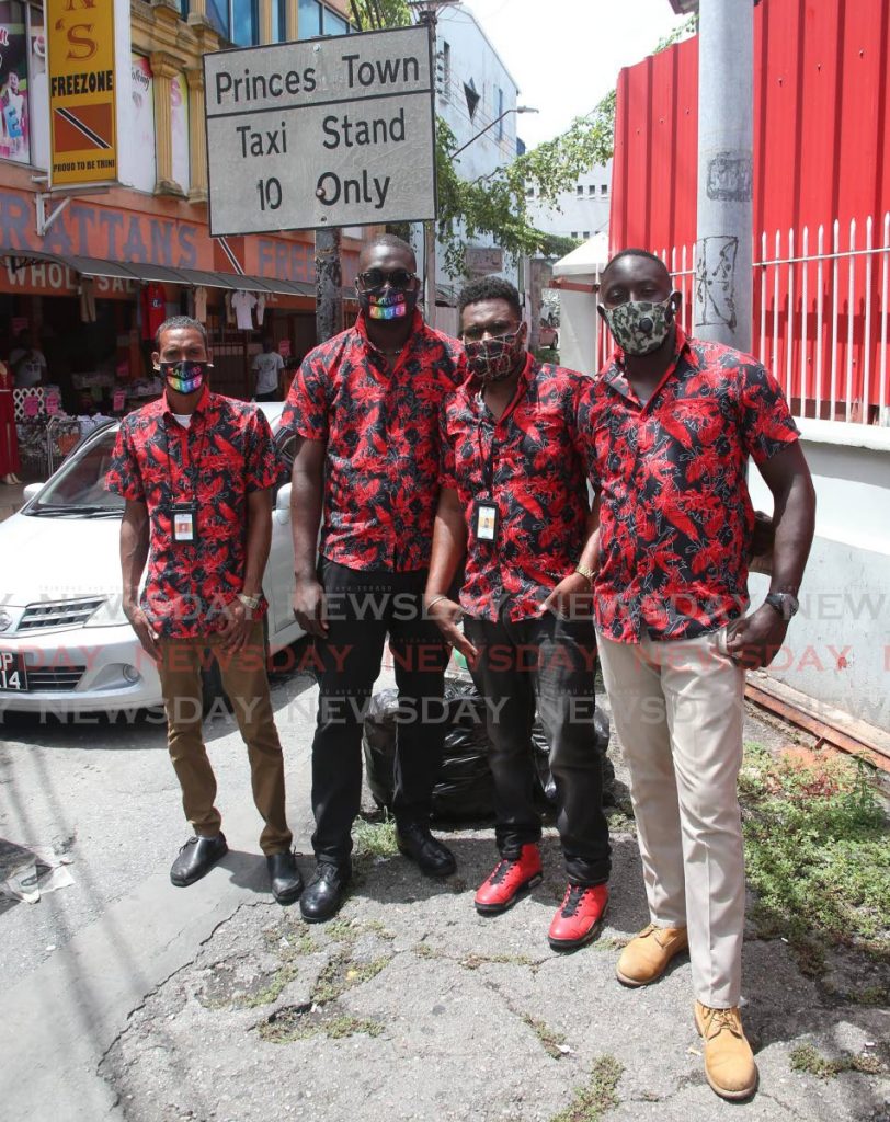 Some of the Princes Town taxi drivers on Library Corner, San Fernando, on Thursday pose with their new shirts. - Angelo Marcelle