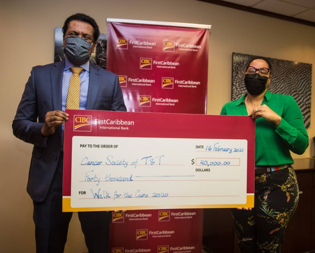 Managing director of CIBC FirstCaribbean Anthony Seeraj presents a cheque to chairman of the TT Cancer Society Dr Asante Le Blanc. - 