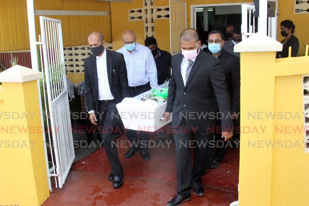 Retired Newsday court editor Azard Ali (left) and Joshua Dhalai (right) lead the pallbearers taking Richardson Dhalai's body out of the Princes Town Open Bible Church on Monday. - Lincoln Holder