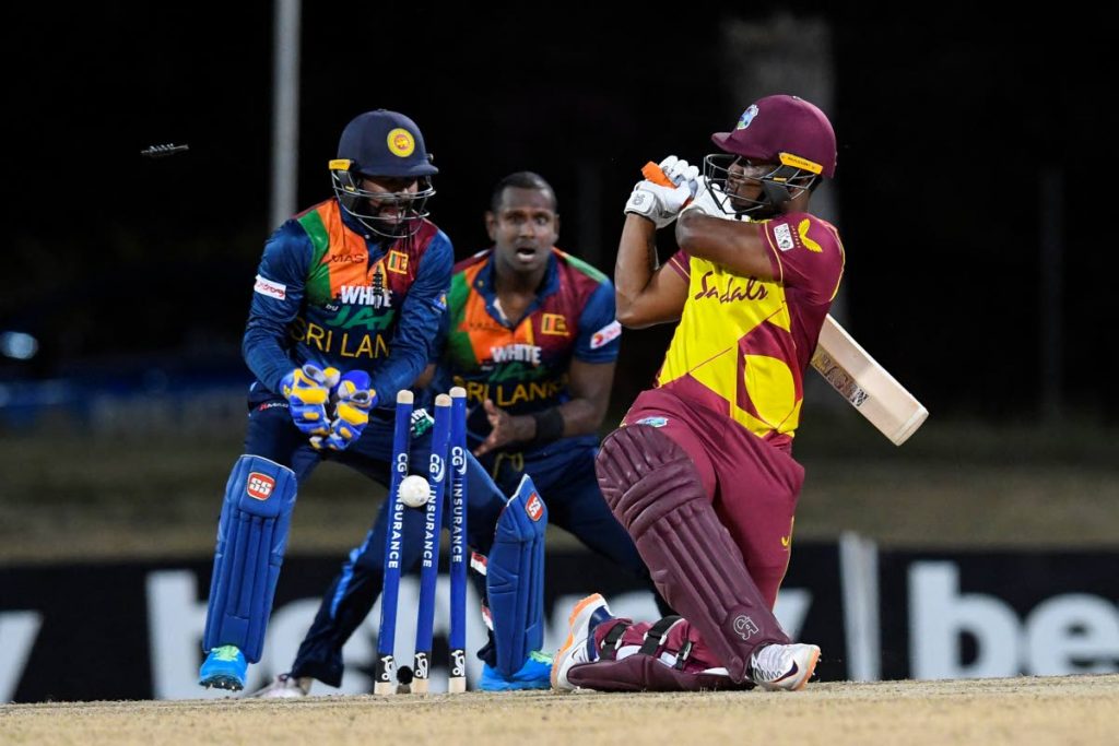 Evin Lewis (right) of West Indies is bowled as Sri Lanka's wicketkeeper Niroshan Dickwella (left) and Angelo Mathews celebrate during the 2nd T20 International match on Friday between Sri Lanka and West Indies at Coolidge Cricket Ground in Osbourn, Antigua. (AFP PHOTO) - 