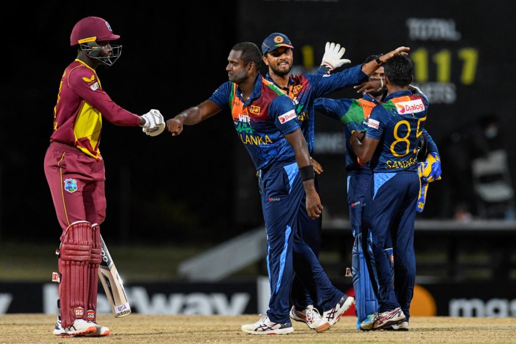 West Indies' Kevin Sinclair (left) and Sri Lanka captain Angelo Mathews (second from left) exchange greetings while fellow Sri Lankans Lakshan Sandakan (right) and Dinesh Chandimal celebrate after Friday's 2nd T20 international at Coolidge Cricket Ground, Osbourn, Antigua. (AFP PHOTO) - 