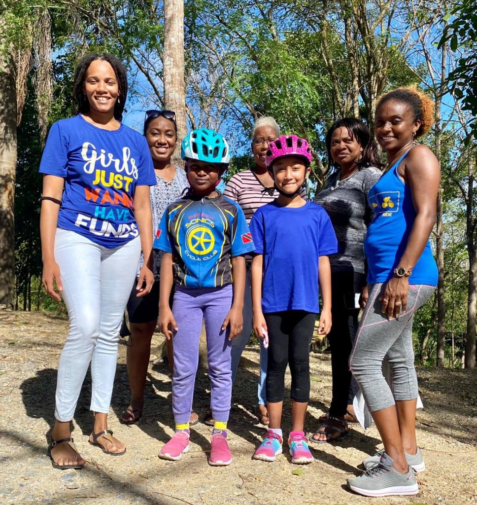 Young Rigtech Sonics cyclists Melina Lopez (blue helmet) and Lisa-Joe Boodhoo (pink helmet) is flanked by parents and TTCF officials at Sunday’s Together We Ride event in celebration of International Women’s Day.  - 