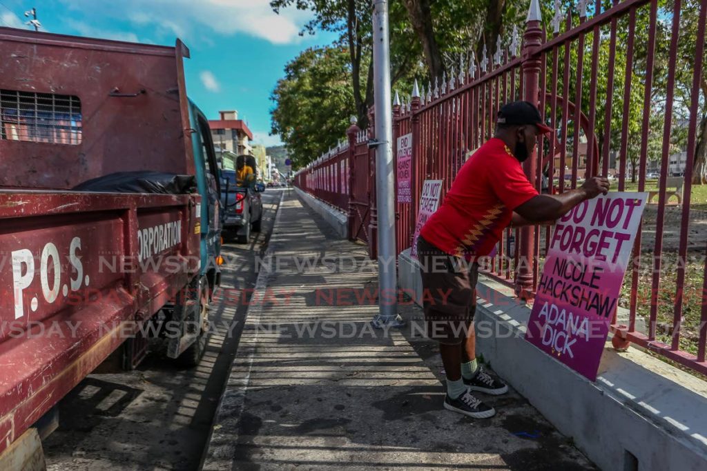 POS Corporation workers of the Parks and Squares Division removing signs erected with the names of women who lost their lives to gender-based violence along Woodford Square, Abercromby Street, port of Spain on Wednesday morning.  - Jeff K. Mayers