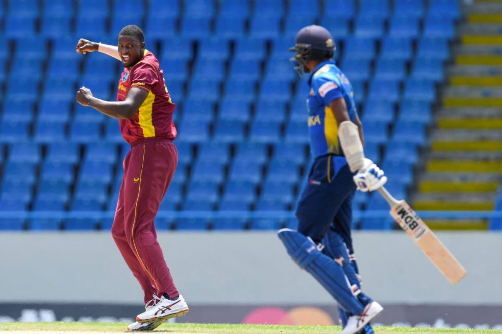 Jason Holder (L) of West Indies celebrates the dismissal of Dushmantha Chameera (R) of Sri Lanka during the 1st ODI, at Vivian Richards Cricket Stadium in North Sound, Antigua , on Wednesday. (AFP PHOTO)  - 