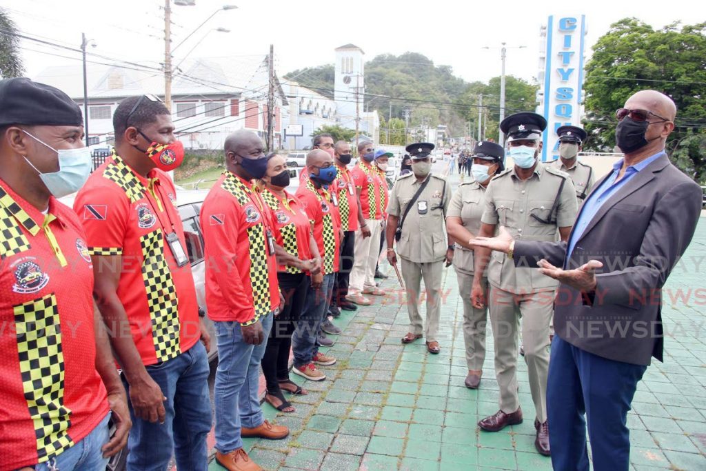 San Fernando mayor Junia Regrello and Supt Ian Carty have a look at the uniforms of the La Romaine-Gulf City Taxi Drivers Association at a launch on Harris Promenade, San Fernando on Thursday. - Lincoln Holder