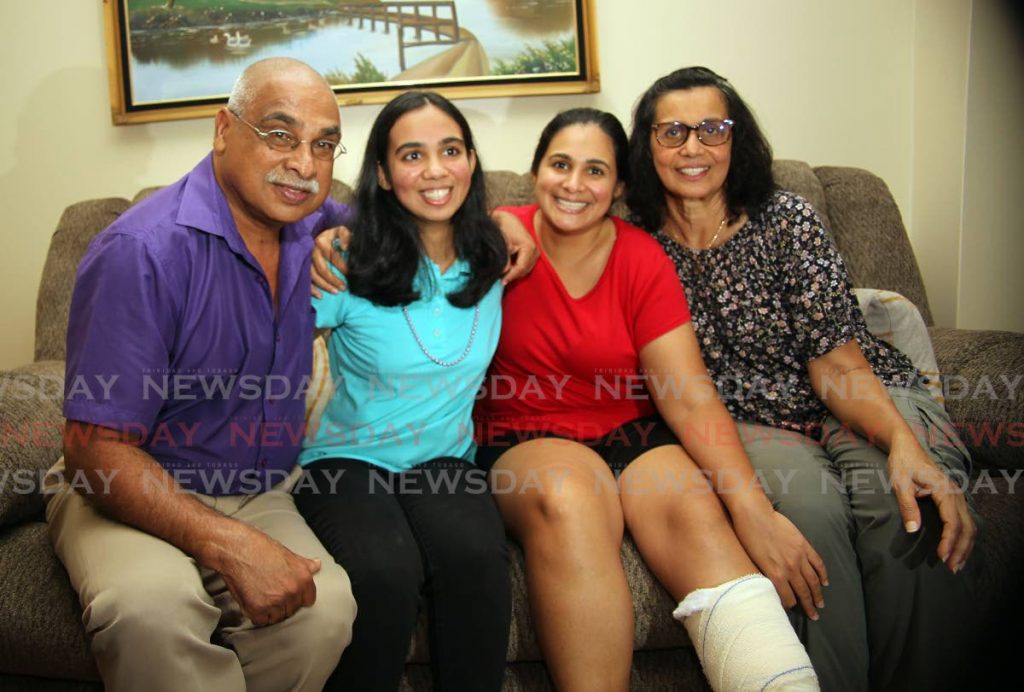 From left: Jinda Maharaj, father of Anjali, centre, who won a President’s Medal is congratulated by her sister  Gina and mother Shrimatee at their home in Gopaul Lands, Marabella.  - Lincoln Holder