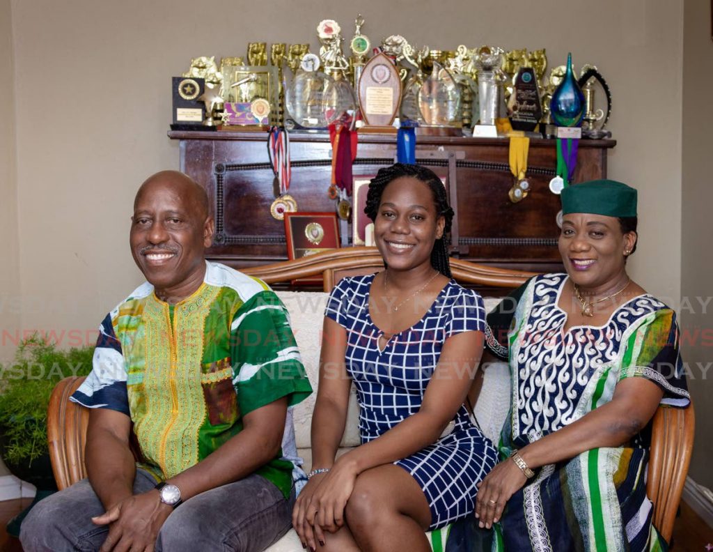 Scholarship winner Treverra James, centre, at her Signal Hill home on Friday with her father Trevor James and mother Sherra Carrington-James. - DAVID REID 