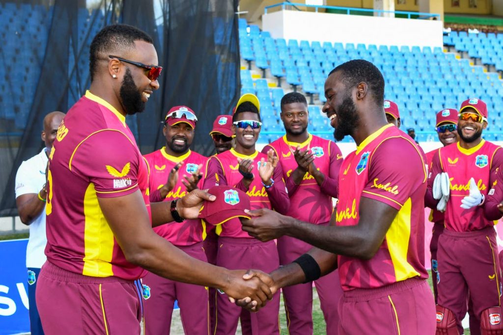 Anderson Phillip (right) receives his debut cap from West Indies captain Kieron Pollard at the start of the 3rd and final ODI match between West Indies and Sri Lanka on Sunday, at the Sir Vivian Richards Cricket Stadium in North Sound, Antigua. (AFP PHOTO) - 