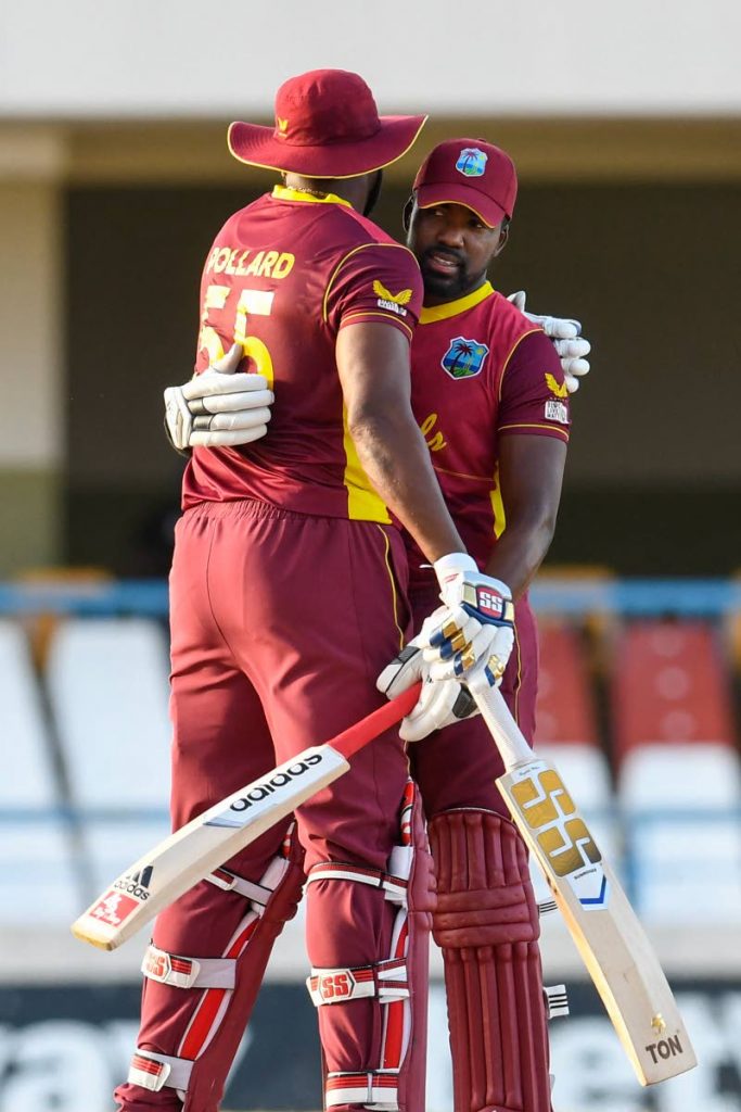 Kieron Pollard (L) and Darren Bravo (R) of West Indies celebrate a partnership of 80 runs during the 3rd and final ODI against Sri Lanka at the Sir Vivian Richards Cricket Stadium in North Sound, Antigua, on Sunday. (AFP PHOTO) - 