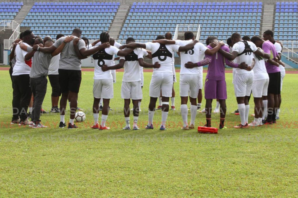 Trinidad and Tobago's footballers huddle during a training session last week at the Ato Boldon Stadium, Couva. Photo by Marvin Hamilton