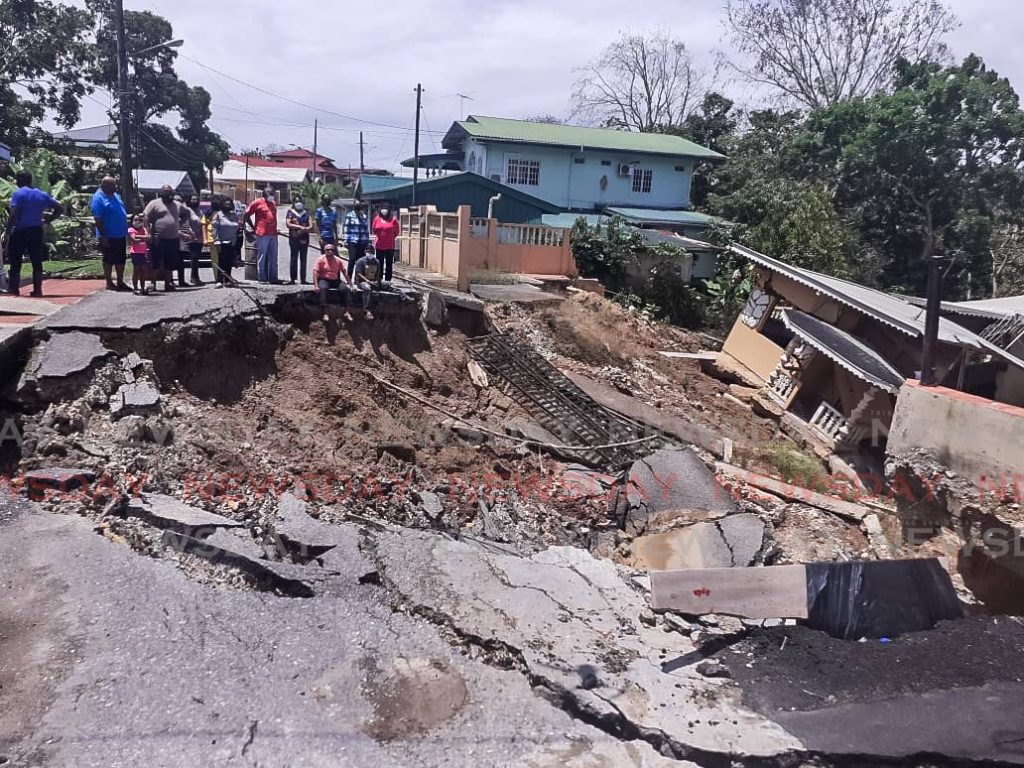 LIVING IN FEAR: Concerned residents of Mandingo Road, Princes Town look at the landslip which has disrupted their lives. - Photo by Laurel Williams