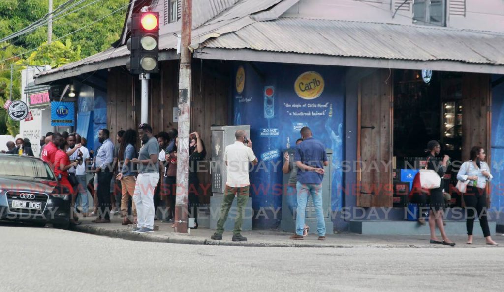 Patrons flock to the popular watering-hole, Brooklyn Bar on Carlos Street in Woodbrook on Friday, breaching the public health ordinance prohibiting people from consuming alcoholic beverages on bar premises. - Photo by Roger Jacob