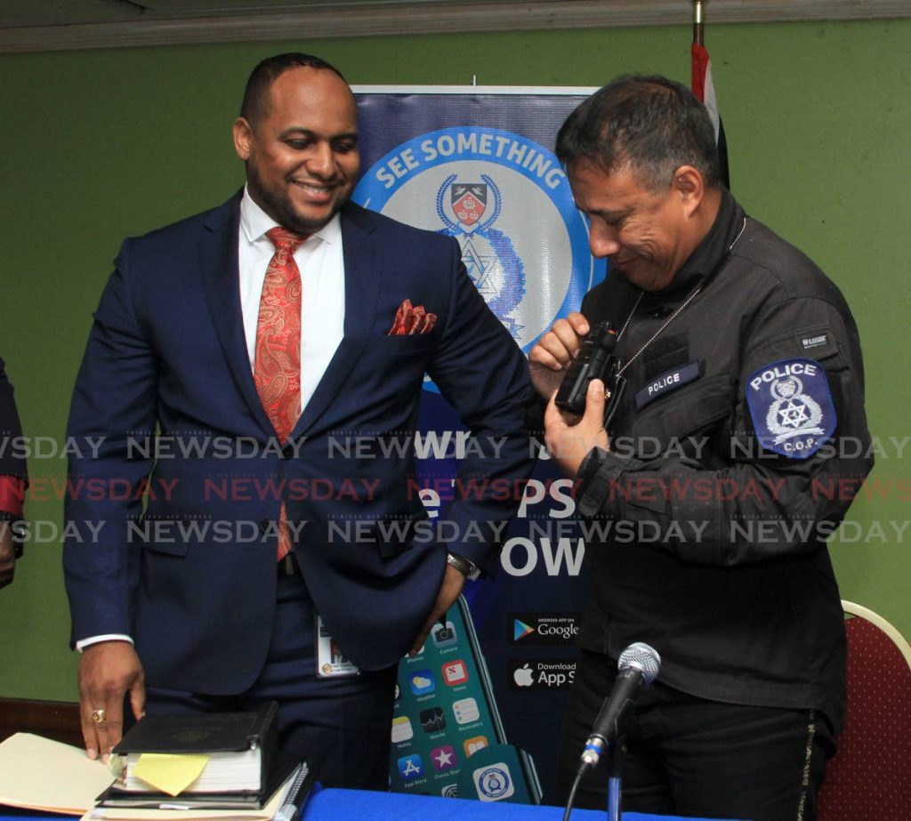 Head of the Legal Unit of the TTPS Christian Chandler looks on as CoP Gary Griffith demonstrates the body camera. - Ayanna Kinsale