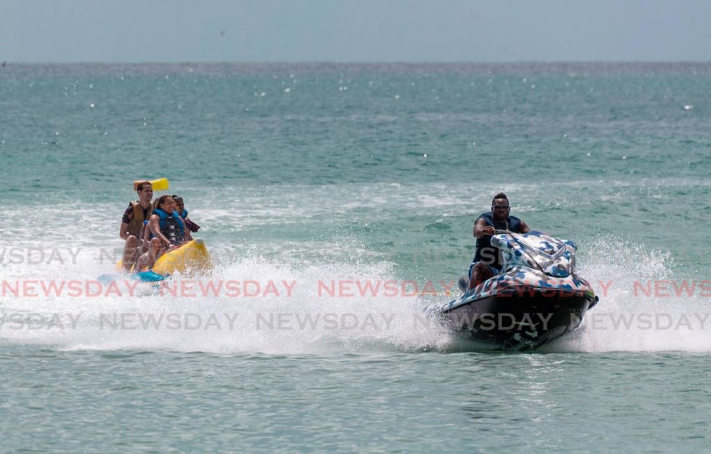 Waterholics founder and jet ski driver Alex Nedd takes visitors out for a spin on a banana boat in Pigeon Point, Tobago on March 21. Photo by David Reid. - 