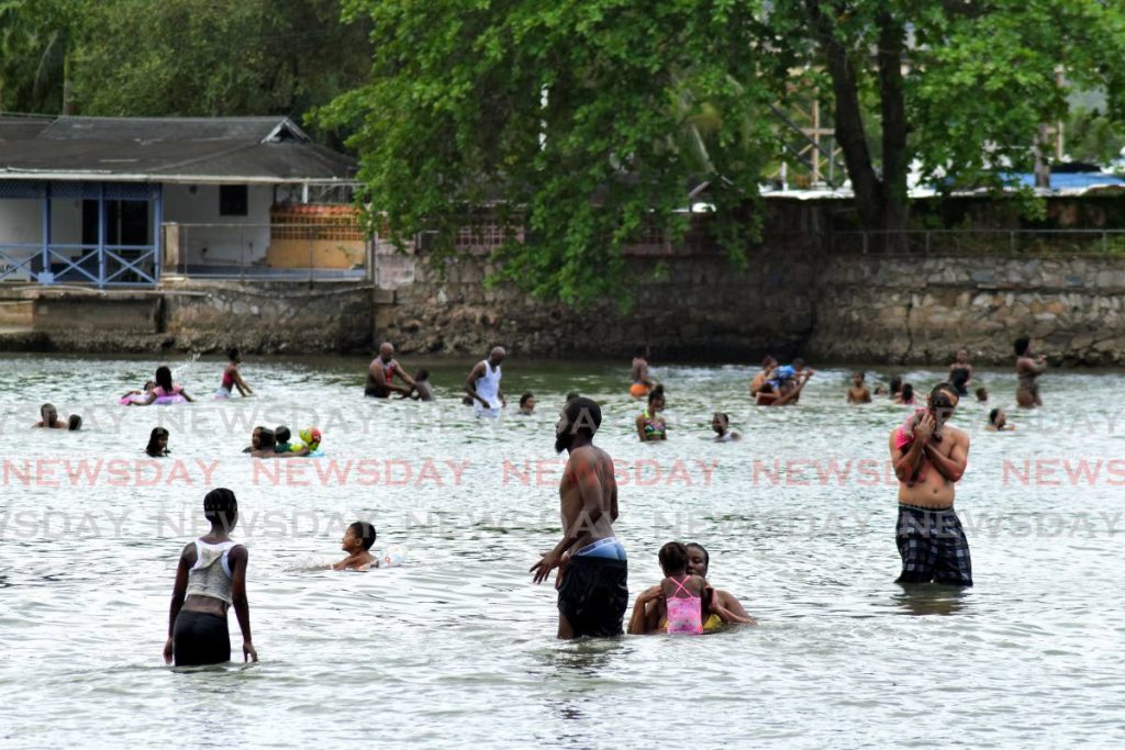 Bathers enjoy Spiritual Shouter Baptist Liberation Day at the beach with their families at Williams Bay, Chaguaramas, on Tuesday afternoon. - Vidya Thurab