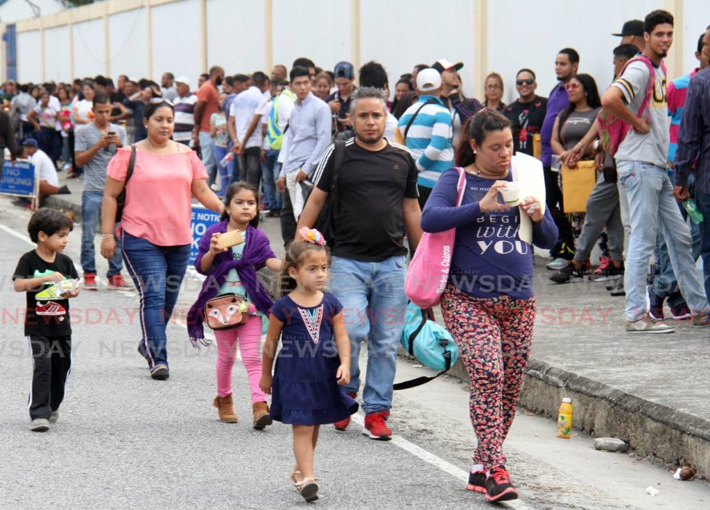In this June 2, 2019 file photo, Venezuelans line up outside the Queen's Park Oval, Port of Spain to be registered under the TT government amnesty. 
