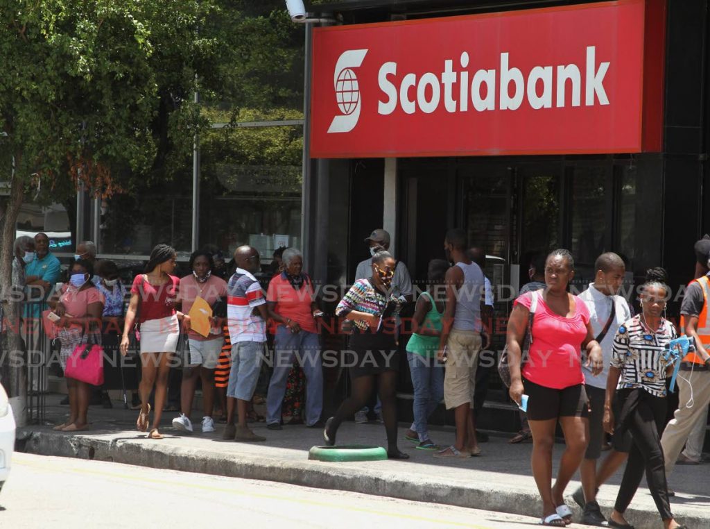 Customers wait to enter a Scotiabank branch in Port of Spain. The Canandian banking group has signed an agreement to sell its Guyana-based branches to TT's First Citizens bank. File photo - 