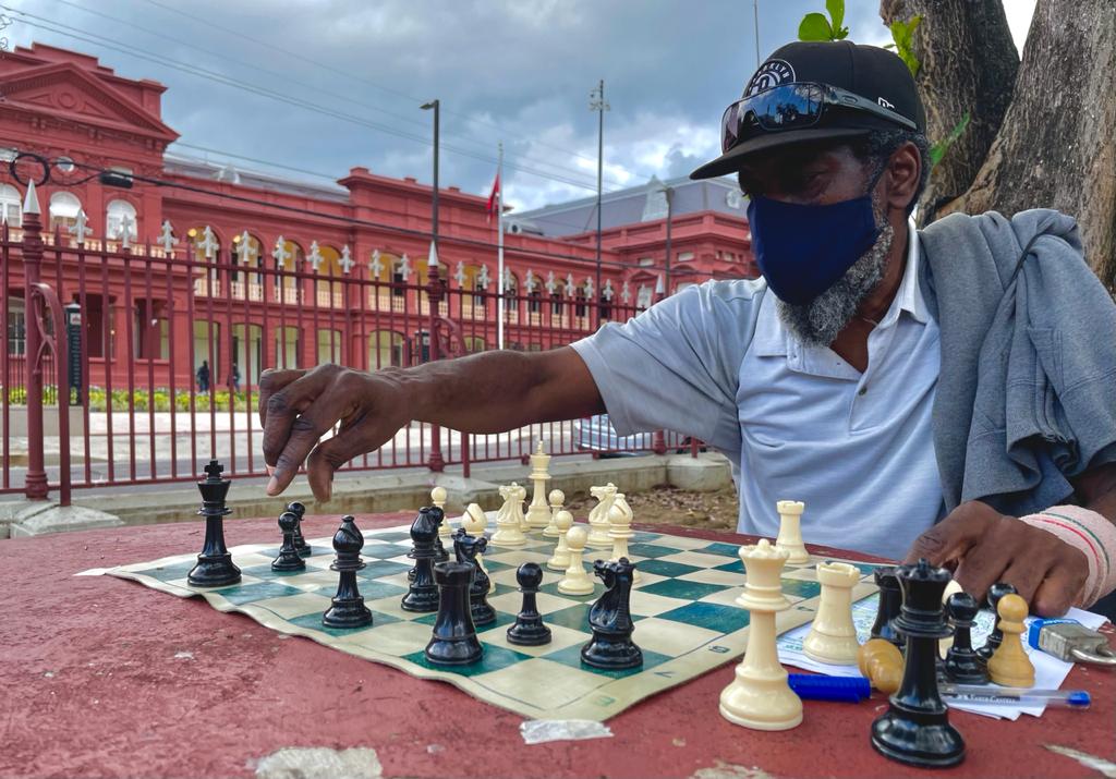 Lennox Maynard plays chess at Woodford Square in Port of Spain. Photo by Kalifa Sarah Clyne