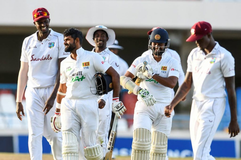 Lahiru Thirimanne (2L) and Dinesh Chandimal (2R) of Sri Lanka laugh with Jason Holder (L) and Hayden Walsh Jr. (C) of West Indies while walking off the field at the end of day 4 of the 2nd Test at the Sir Vivian Richards Cricket Stadium in North Sound, Antigua, on Thursday. - (AFP PHOTO)