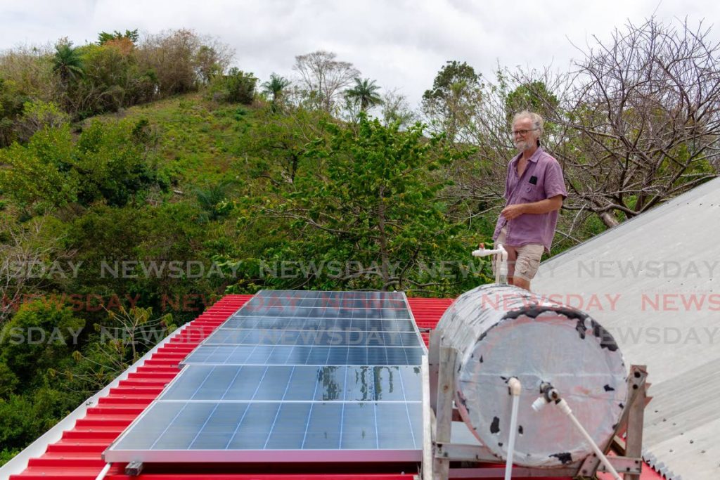 Wildlife conservator Ian Wright looks out at the forest view over the solar panels that powers his home in Mason Hall, Tobago. Photo by David Reid. 