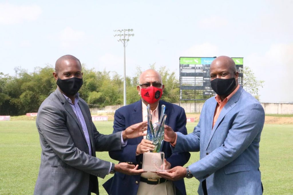 Officials of the Sport Company of Trinidad and Tobago, Kairon Serrette, left, and Justin Latapy-George, right, flank president of the TT Cricket Board (TTCB) Azim Bassarath who is holding the CG Insurance Super50 trophy which the TT Red Force won earlier this year in Antigua. - Photo courtesy TTCB