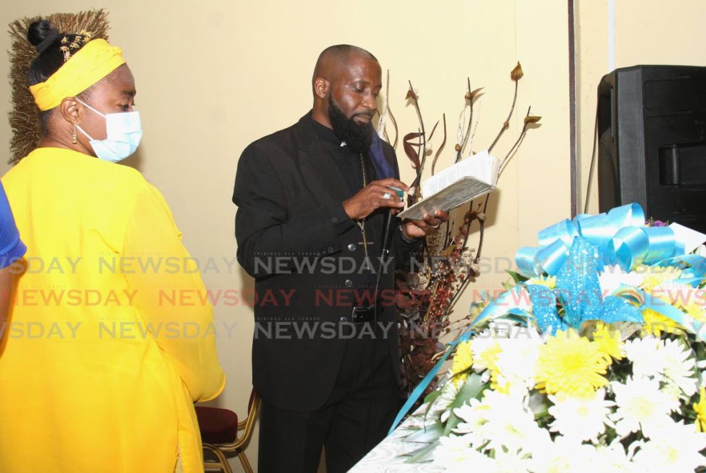 Reverend Richard Wickham prays for Antonio Francois, alongside Nicole Brathwaite, mother of the murdered 15-year-old, during the funeral in Port of Spain on Saturday. - 