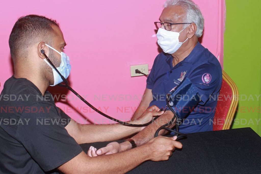 Dr Tim Hosein checks the blood pressure of Minister of Health Terrence Deyalsingh at the opening new Islamic Fada'il Services Trust Ash-Shiffa Medical and Welliness Centre at Felicity, Chaguanas, on Sunday. - CHEQUANA WHEELER