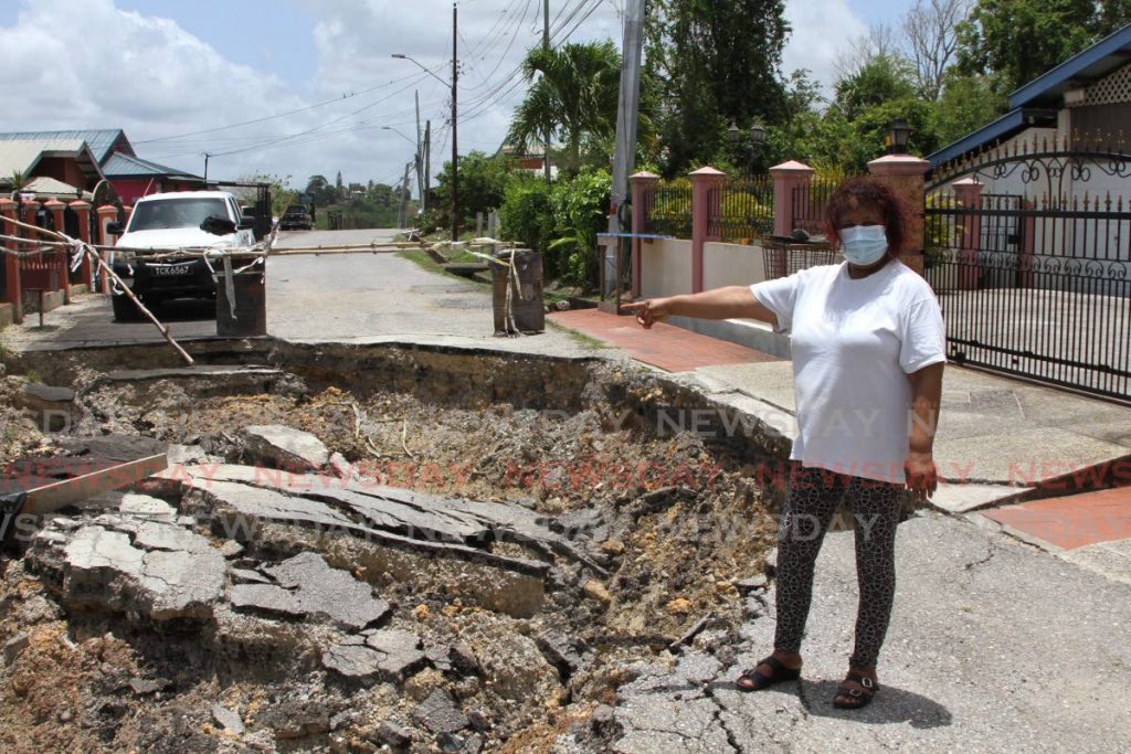 On Tuesday, Shamina Mohamed of Mandingo Road, Princes Town, points to a major landslip that threatens her home and others nearby also making the road impassable to motorists. Photo by Marvin Hamilton