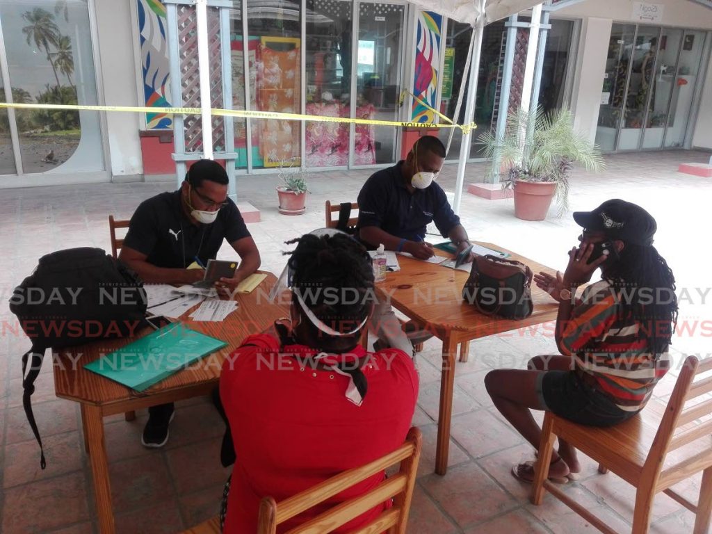 PROCESSED: Two TT Immigration officers, top of photo, interview two people on Wednesday in St Vincent who sought to get exemptions to board the MV Galleons Passage which was due to sail for Port of Spain on Wednesday night. PHOTO BY STEPHON NICHOLAS - 