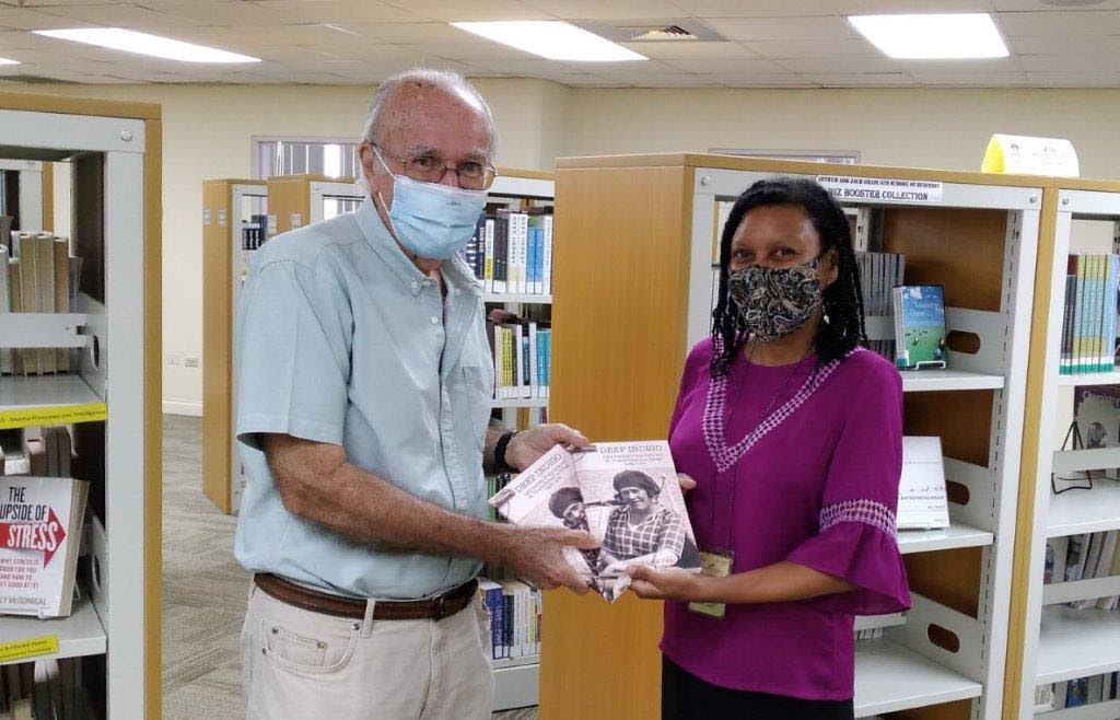 Alex de Verteuil presents the books to librarian Gabrielle Fernandes on behalf of his cousin, the author Elizabeth Cadiz Topp.  - 